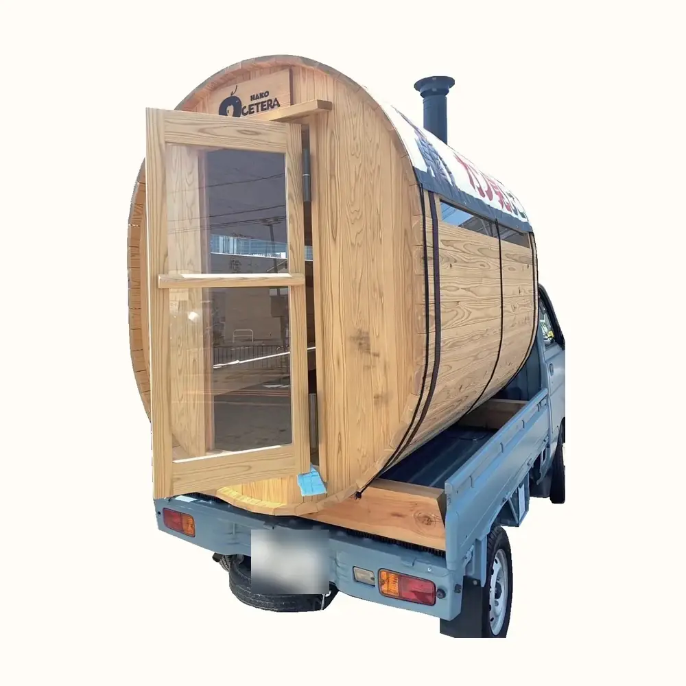 軽トラックの荷台に積まれた木製バレルサウナ。扉が開き、煙突が立っている